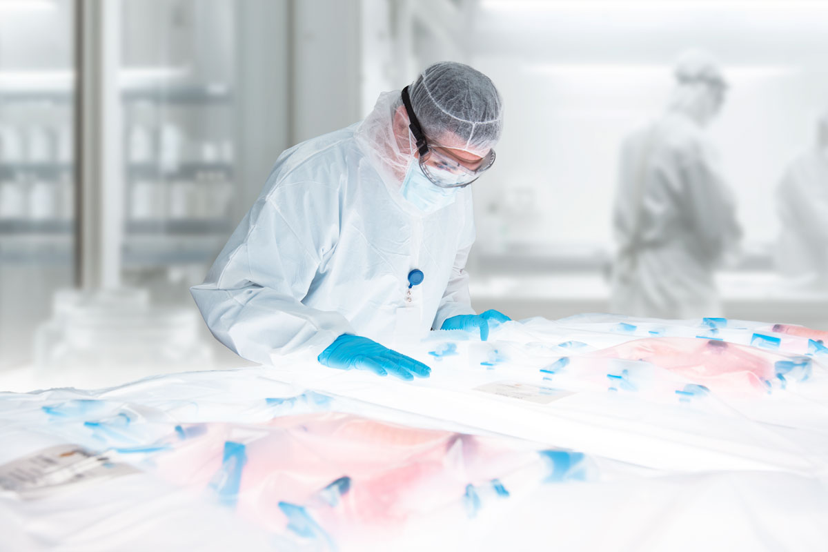 Scientist examining samples in sterile laboratory environment.
