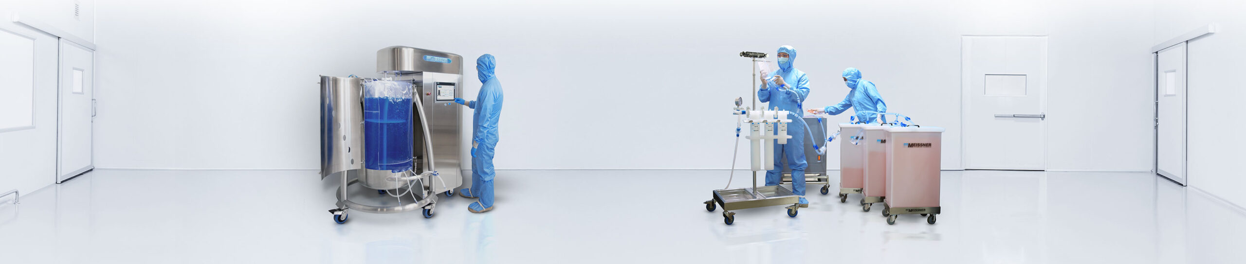 Scientists in lab gear next to equipment in cleanroom.