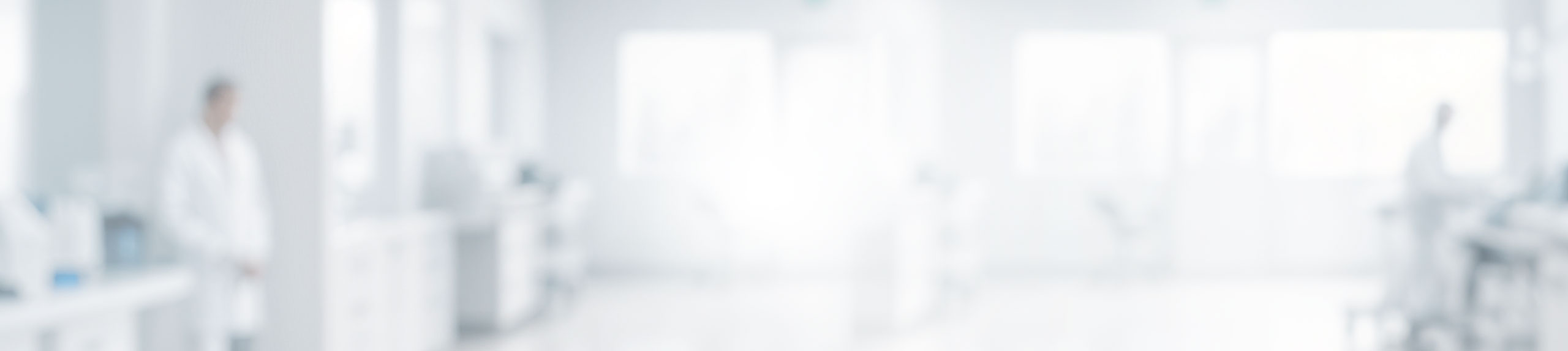 Blurry laboratory with person in white coat.