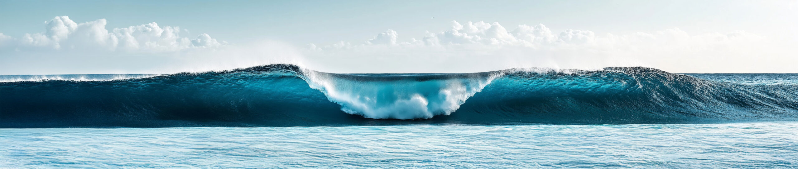 Ocean wave crashing under cloudy sky